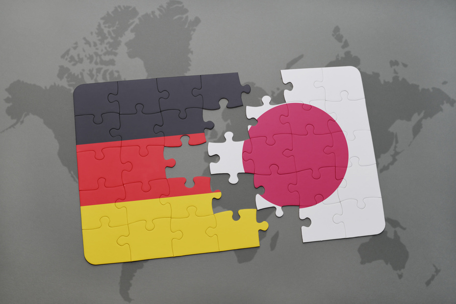 Puzzlestück aus den Fahnen Japans und Deutschlands