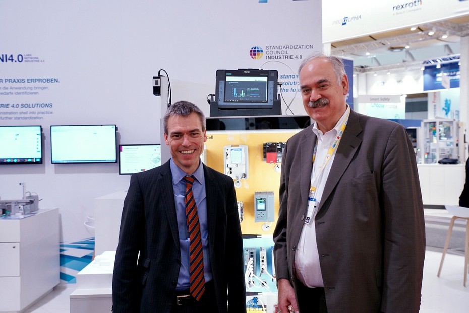 Henning Banthien (Plattform Industrie 4.0 Secretary General, l.) and Dr. Richard Mark Soley (Executive Director of the Industrial Internet Consortium) at the Plattform Industrie 4.0 Hannover Messe booth, 1.4.2019   